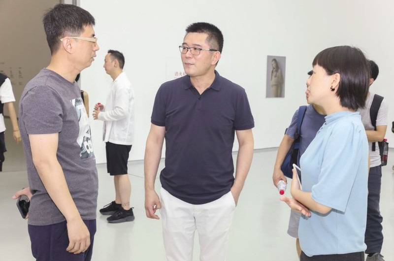 蜂巢当代艺术中心创始人夏季风(中)在展览现场 bd0vtcSL0UBmvrYKeuQFvYzmYcSonRqyG54fiFgy.png