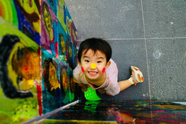 彩色圆点艺术空间变成孩子们的小小游乐场，玻璃上一个个色彩斑斓的圆点贴纸映衬着他们的笑脸。
