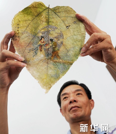 这是8月12日拍摄的苏州艺人庞彦德制作的树叶烙画作品《鹊桥相会》。