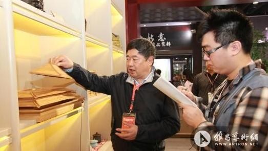 故宫博物院院长单霁翔在第9届中国（义乌）文化产品交易会现场，他正在向记者介绍的就是“太和海”太和殿造型茶海组　应妮　摄