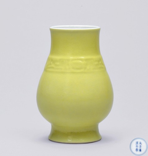 柠檬黄釉仿古模印兽面纹觯形瓶